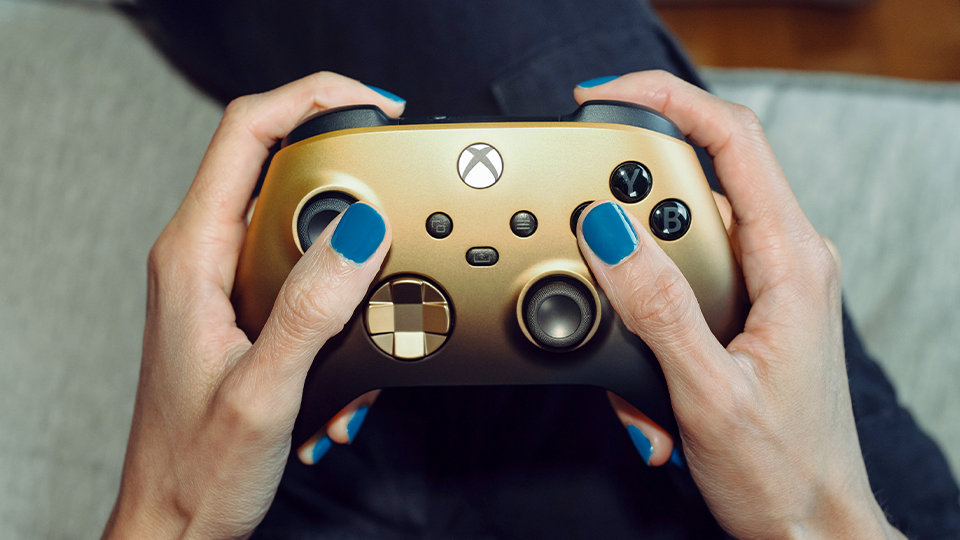 Zbliżenie na przyciski Xbox, widoku, menu i udostępniania na kontrolerze bezprzewodowym do konsoli Xbox – wersja specjalna Gold Shadow. 