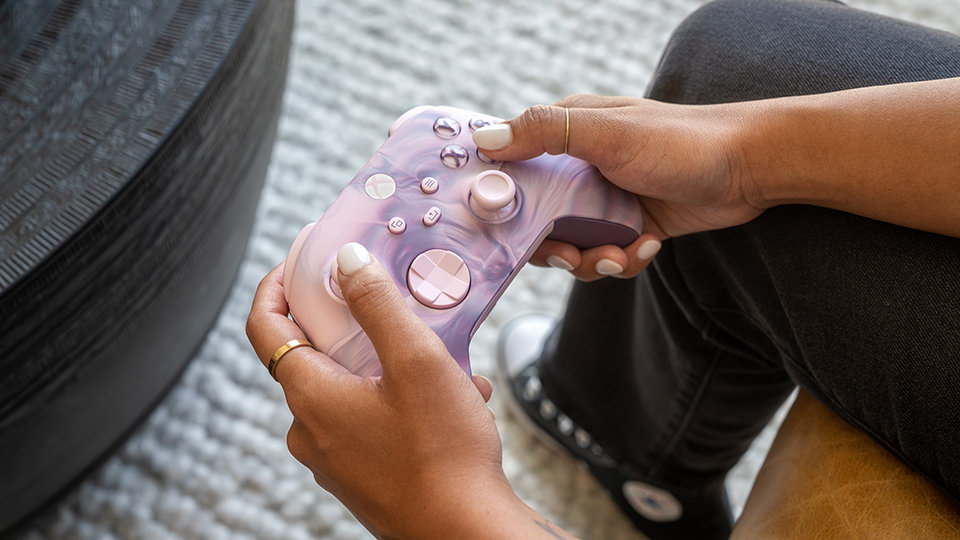 Angle avant d’une personne tenant la manette sans fil Xbox – Édition spéciale Dream Vapor.