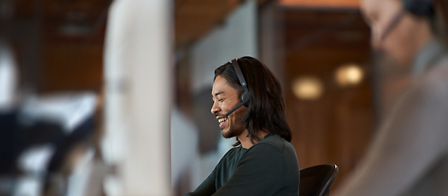 Two people working in office with headsets on.