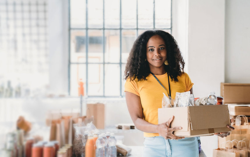 Volunteer woman holding a box of food and drinks 