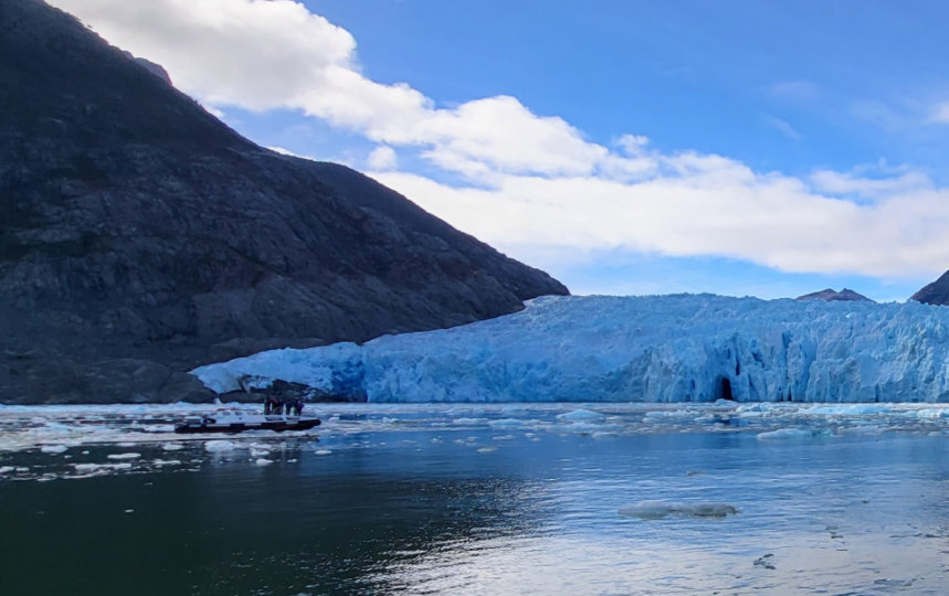 Small research vessels in a bay by the edge of a glacier. 