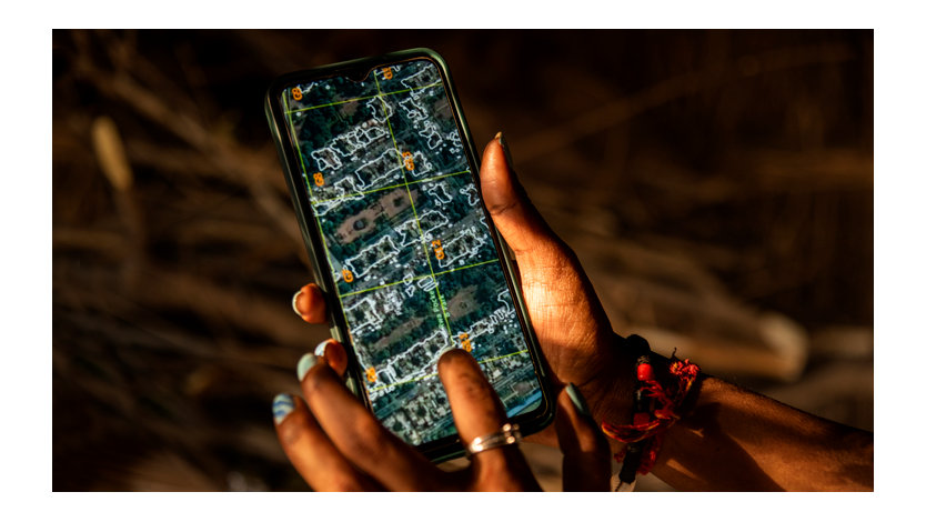 Hands holding a smartphone with an image of a map on the screen.