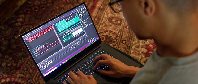 A man is using a laptop on a rug