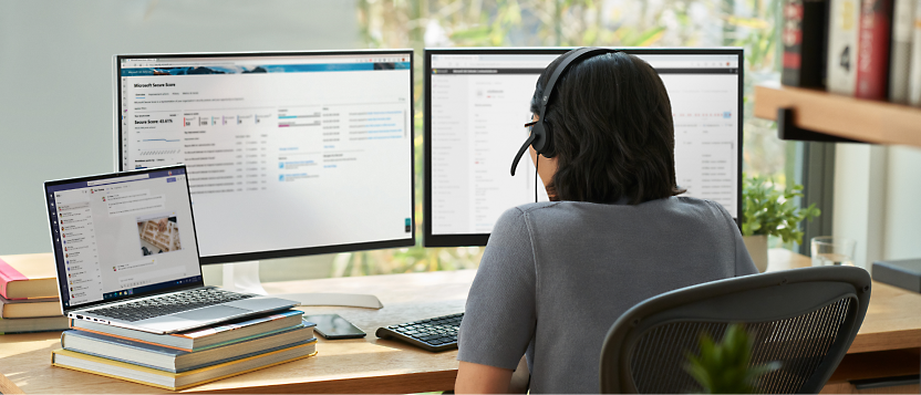 A person wearing headphones looking at computer screens.