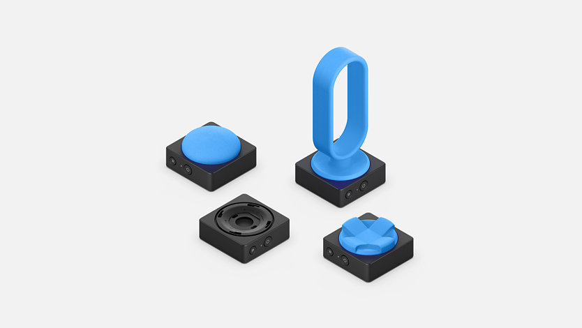 Microsoft Adaptive Button-forekomster med topper i ulike former og størrelser som er skrevet ut i 3D.