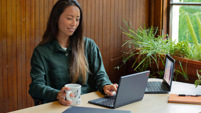 Een vrouw die aan een tafel zit en een videogesprek aanneemt