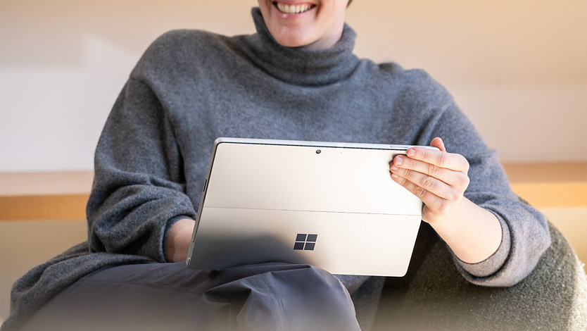 A person holds a Surface for Business device. 