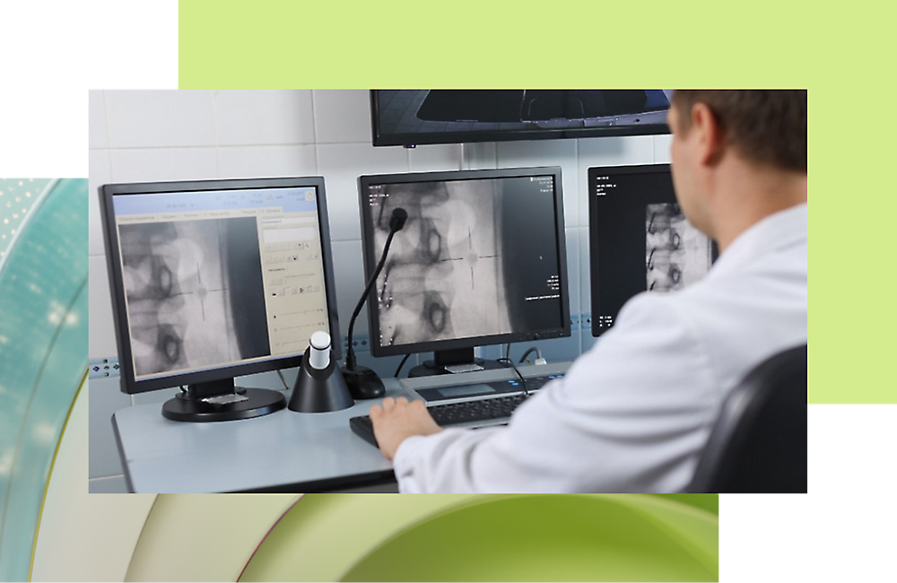 A doctor looking at a x-ray in multiple monitors