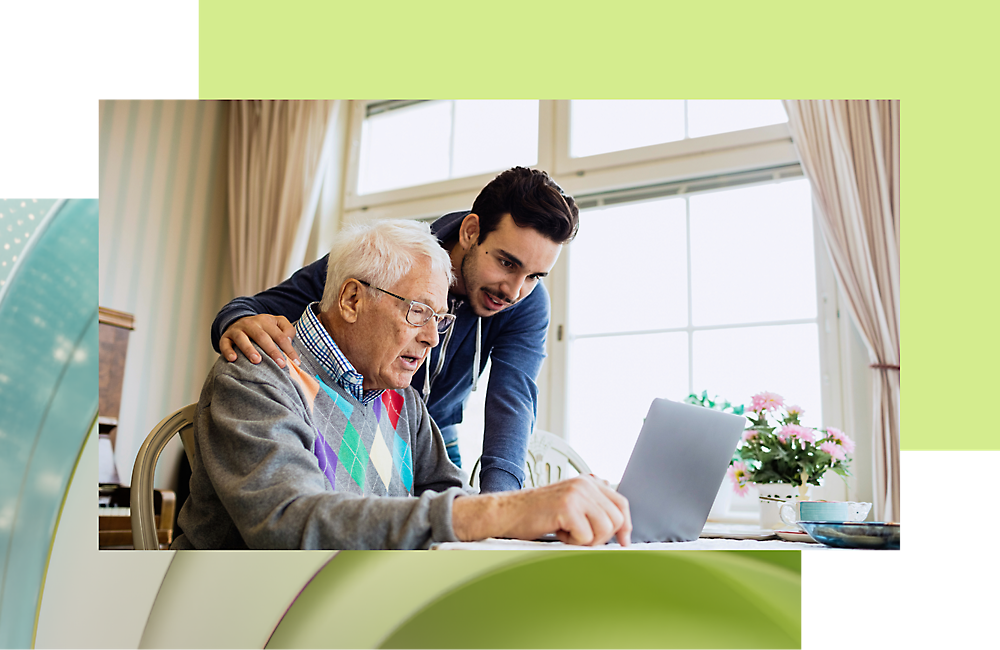 A person looking at a computer and talking with an older individual