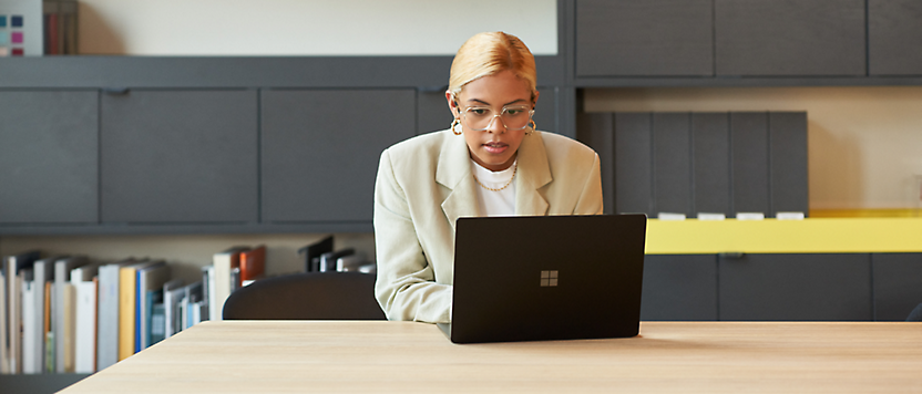 A person sitting at a desk looking at a computer