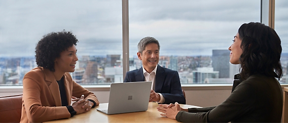 A group of people sitting around a table in an office.