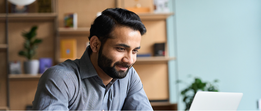 A person with a beard looking at laptop.