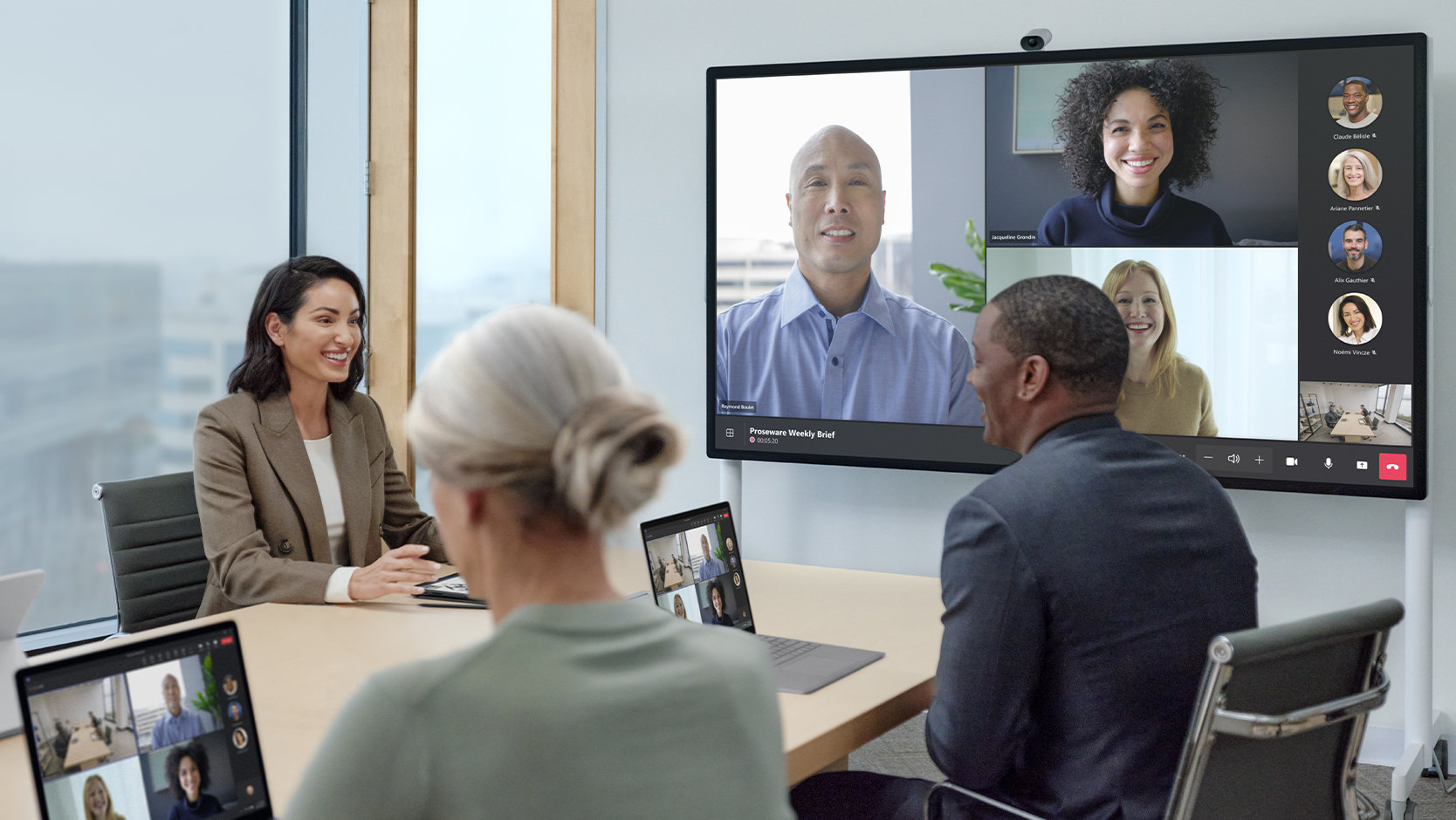 Team members who are in-office and remote use a Surface Hub 3 for Business and a Surface Hub Smart Camera to meet on Microsoft Teams. 
