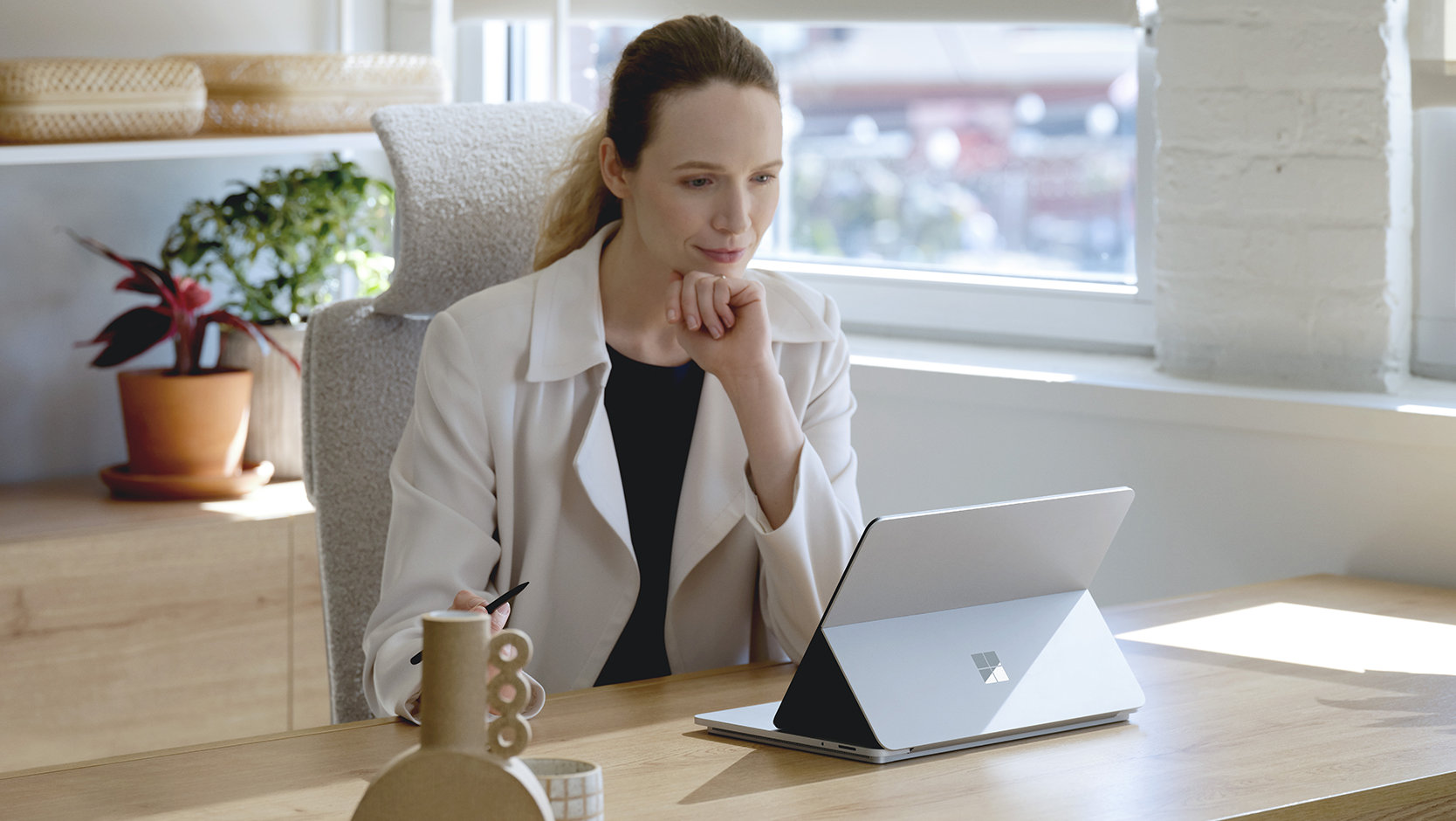 A person uses a Surface device while sitting at a desk.