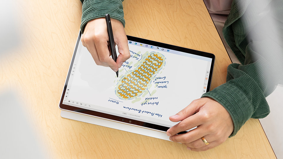 A person uses a Slim Pen 2 for Business on the touchscreen of a Surface Pro 9 for Business. 