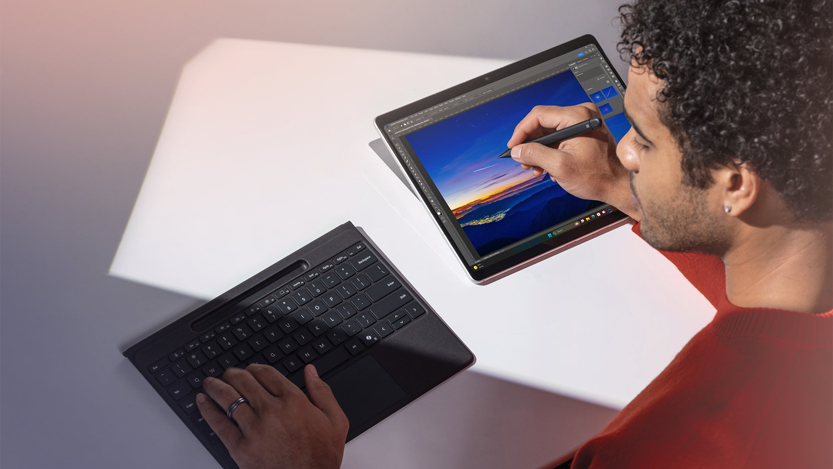 A person types on a detached Surface Pro Flex Keyboard for Business while drawing on the screen of a Surface device with a Surface Slim Pen for Business. 