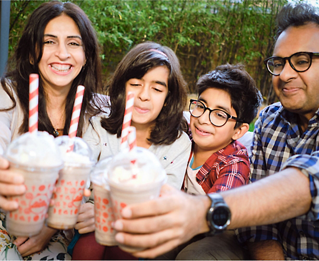 A group of people outside smiling and enjoying a shake