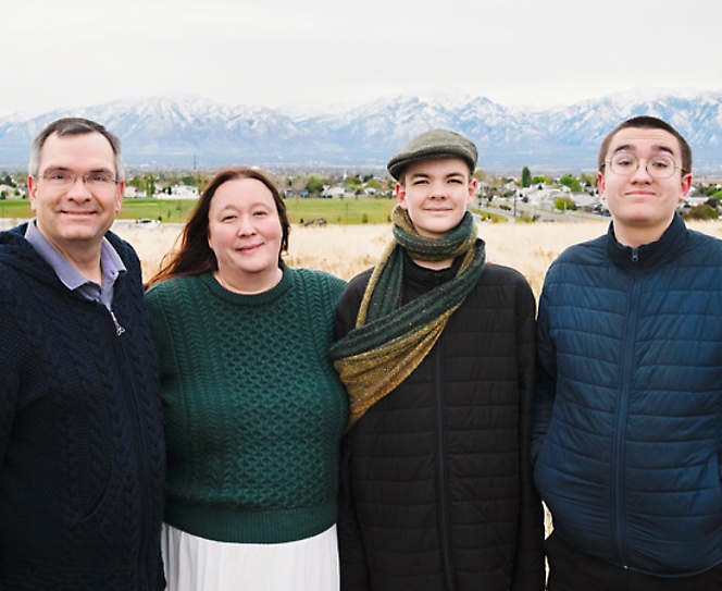 Group of people posing for a photograph with mountains in background