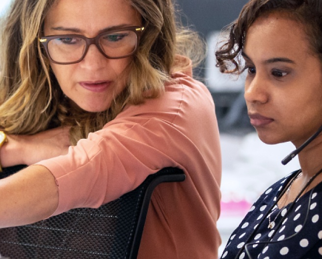 Two women are sitting and looking at the laptop