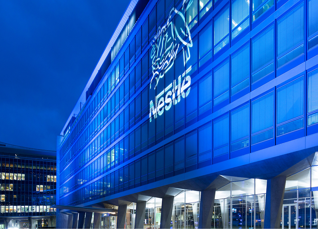 A building lit up at night with a blue sign.