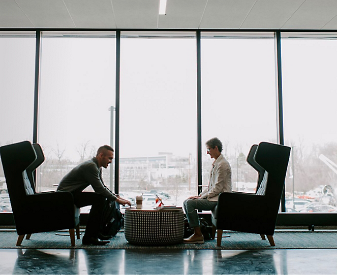 Two people sitting in office on sofa