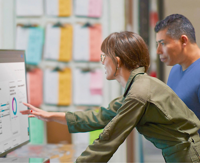 Two persons looking at the dashboard in the monitor