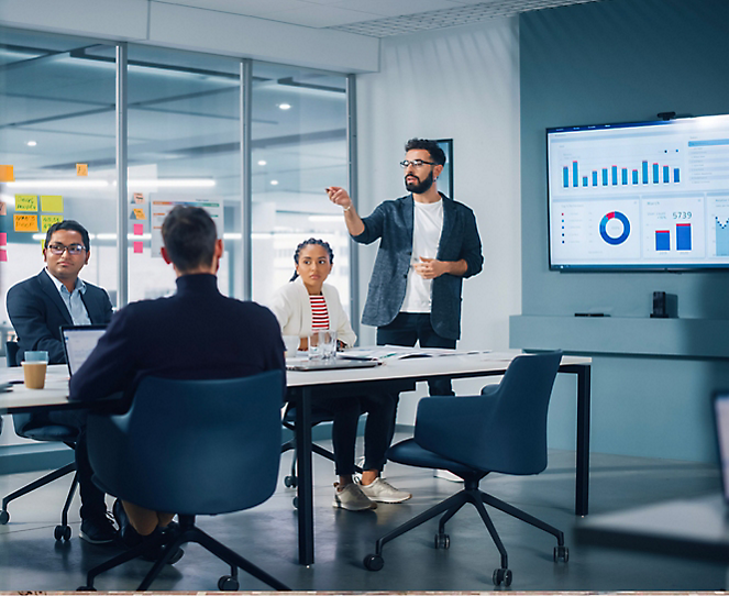 A group of people in a meeting with presentation on the screen