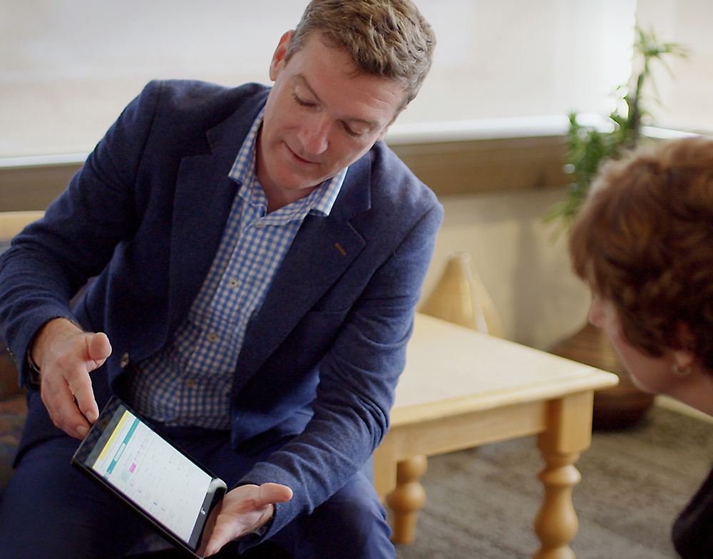 A person in a suit holding a tablet