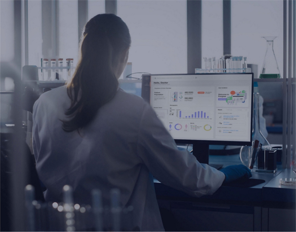 A person in a lab coat working on a computer