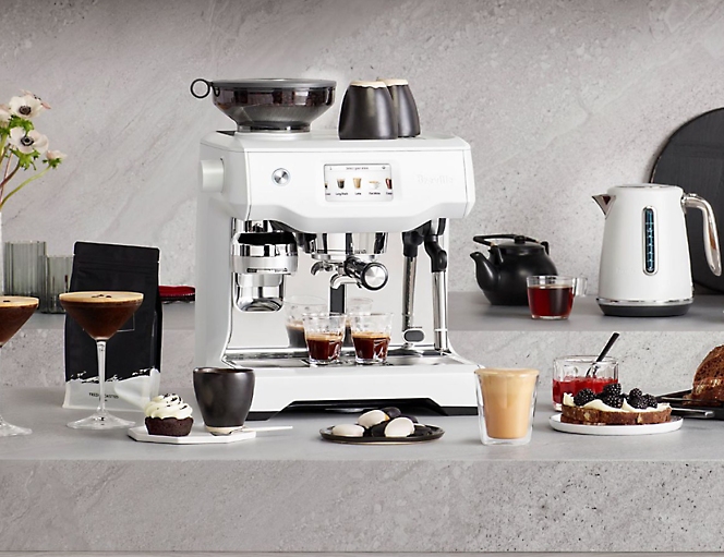 A white coffee machine is sitting on a counter.