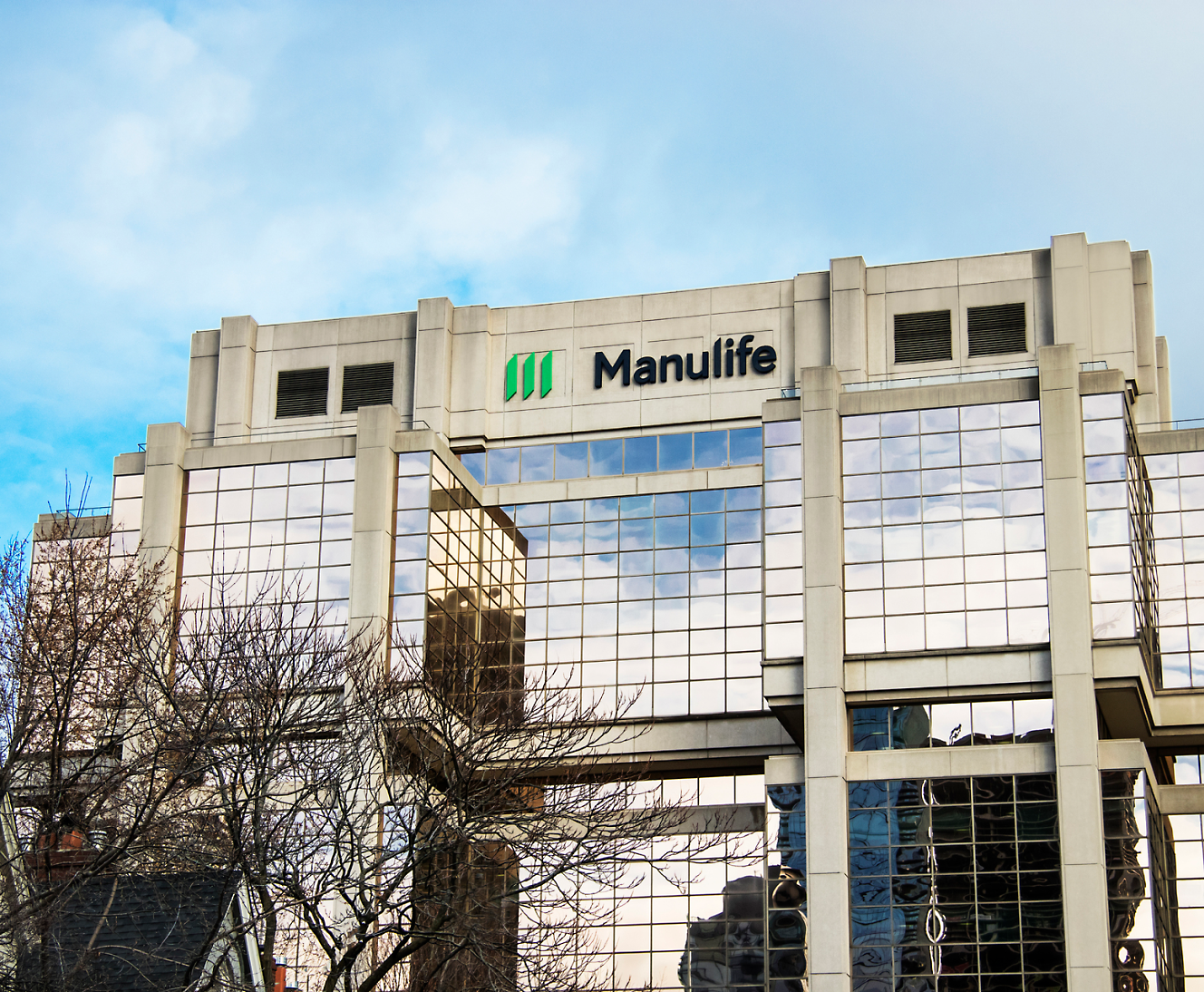 Внешний вид здания Manulife с его логотипом, отражающими стеклянными окнами и современным архитектурным дизайном.