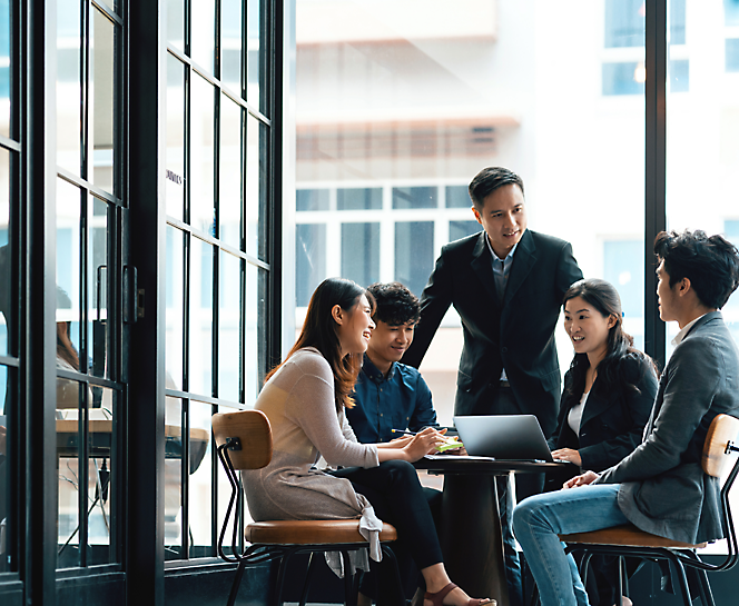 A group of people sitting around a table and talking with each other