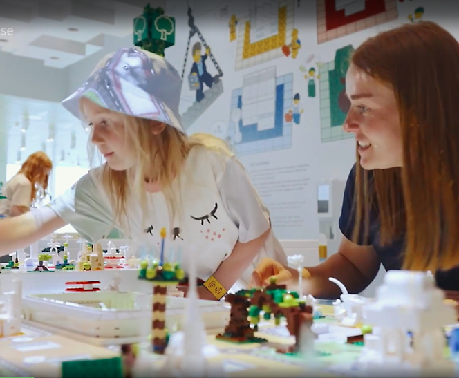 Взрослый и ребенок играют в конструктор "Лего"