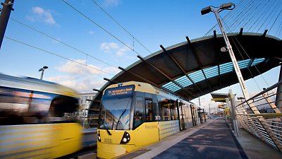 Ein gelb-schwarzer Zug hält in einem Bahnhof.