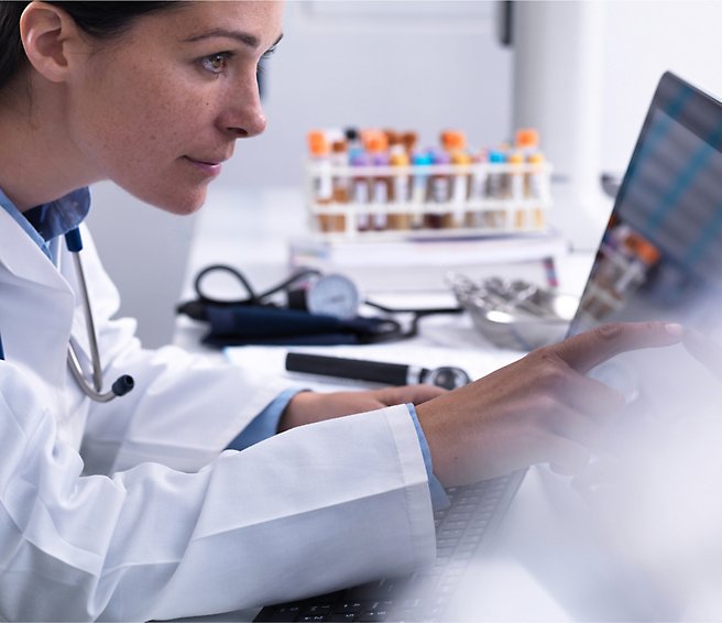 A Doctor in a white coat using a computer