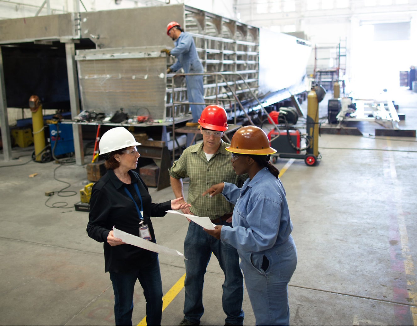 Group of people wearing safety helmets and discussing at a construction site