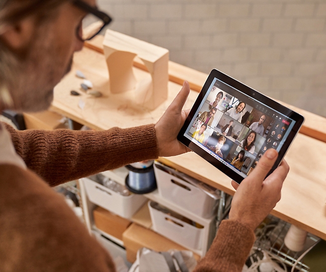 Ein Mann mit Brille, der ein Tablet hält