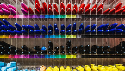 Collection of colorful pens on a shelf.