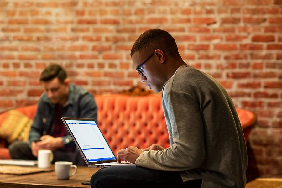 People sitting in a café and using mobile devices and laptops