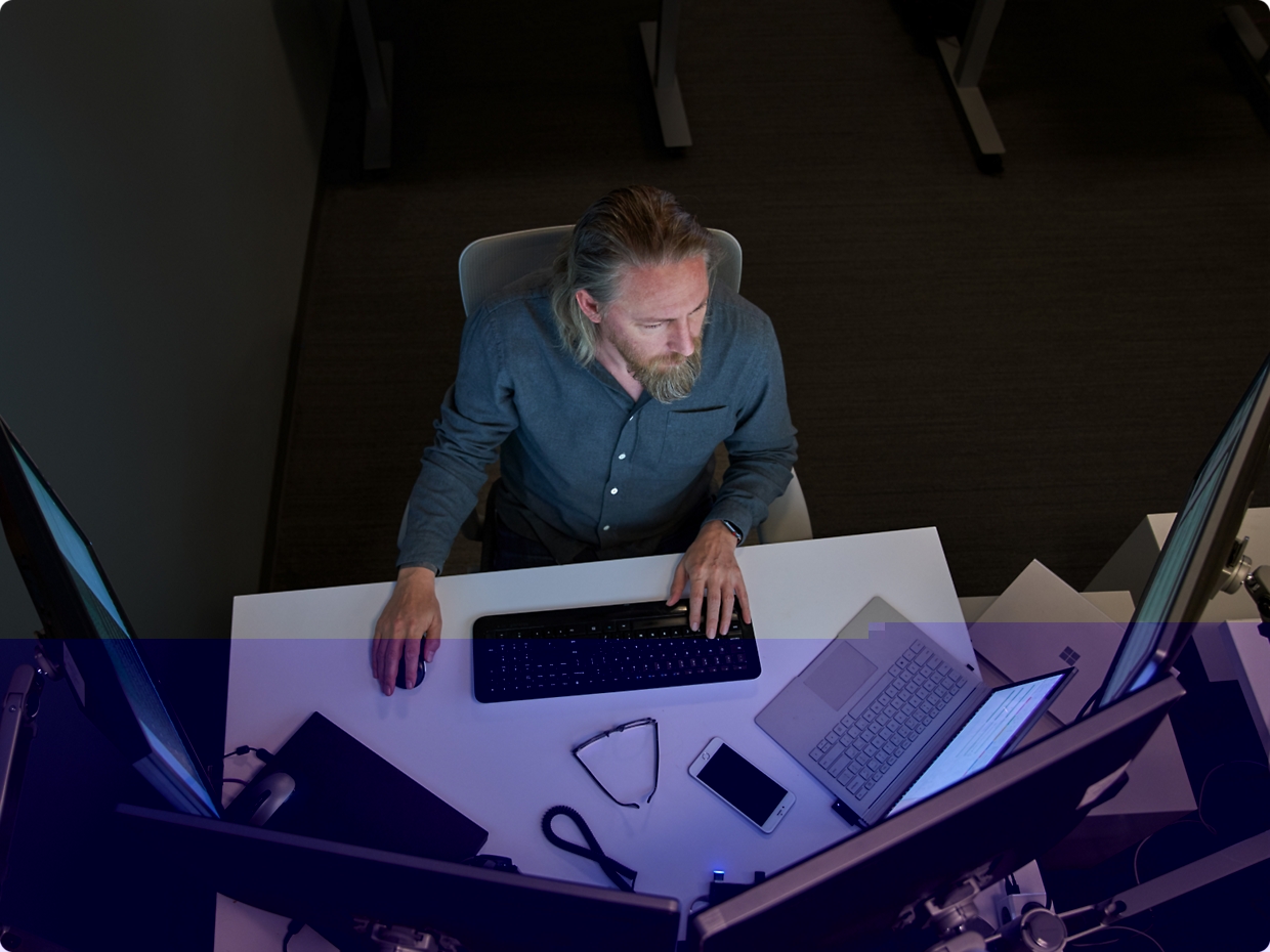 Zwei Männer, die sich auf einen Computerbildschirm in einer Büroumgebung konzentrieren, einer stützt sein Kinn auf der Hand.