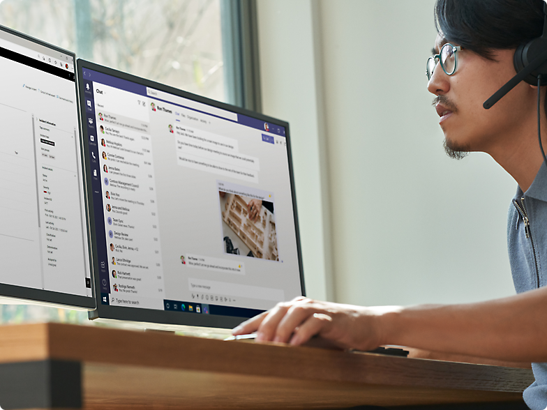 Ein Mann mit Kopfhörern arbeitet an einem Computer mit mehreren Monitoren, auf denen Diagramme und Text angezeigt werden.