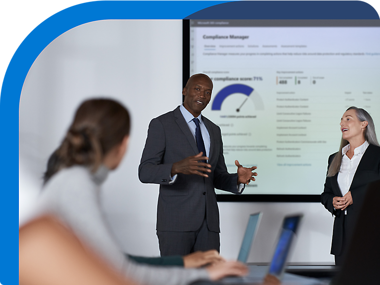 A group of people standing in front of a screen in a conference room.