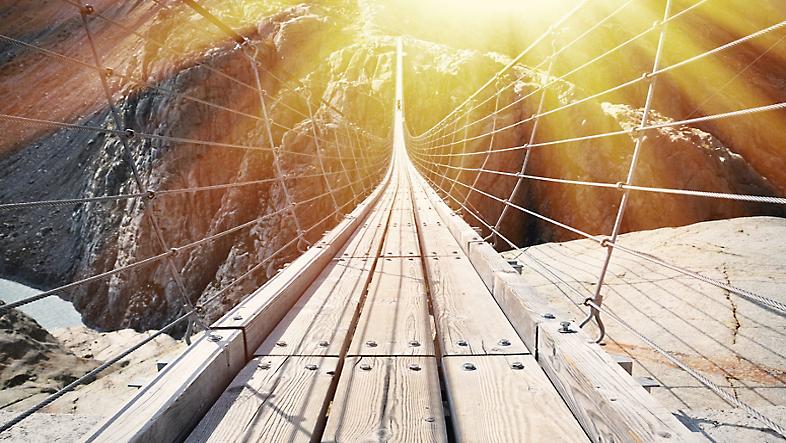 A wooden floating bridge crossing over a canyon