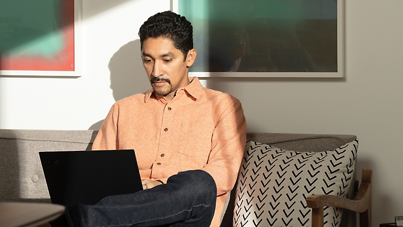 A person sitting on a couch using a laptop