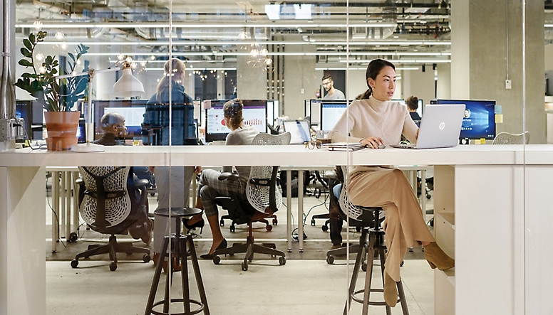 En kvinne sitter ved et skrivebord på et kontor.