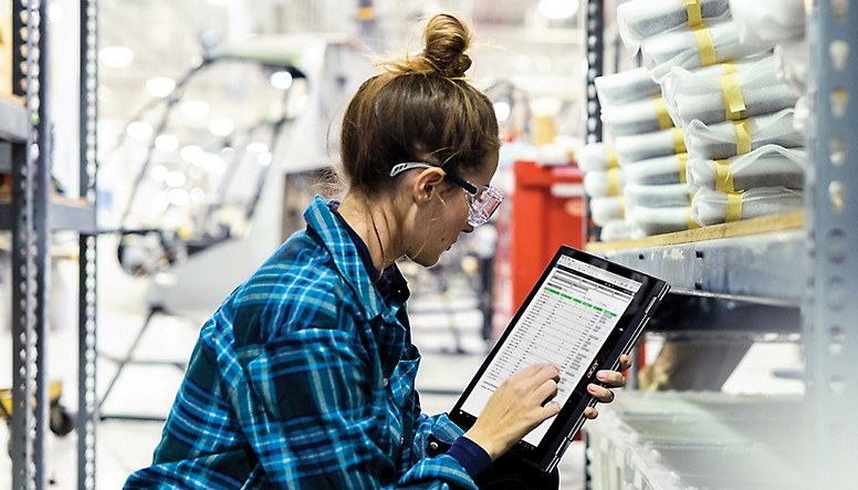 Una mujer usando una tableta en un almacén.