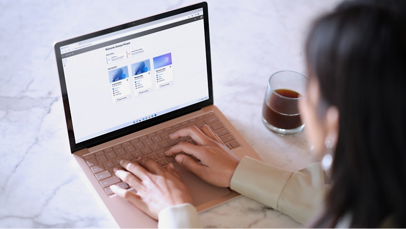 Een persoon die op een laptop typt waarop de startpagina van Windows 365 wordt weergegeven