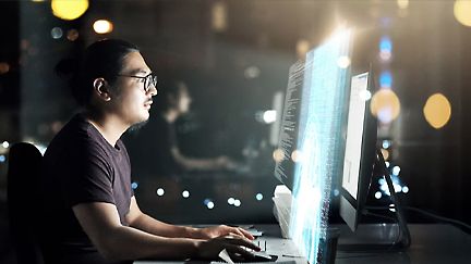 A person sitting at a desk looking at a computer screen