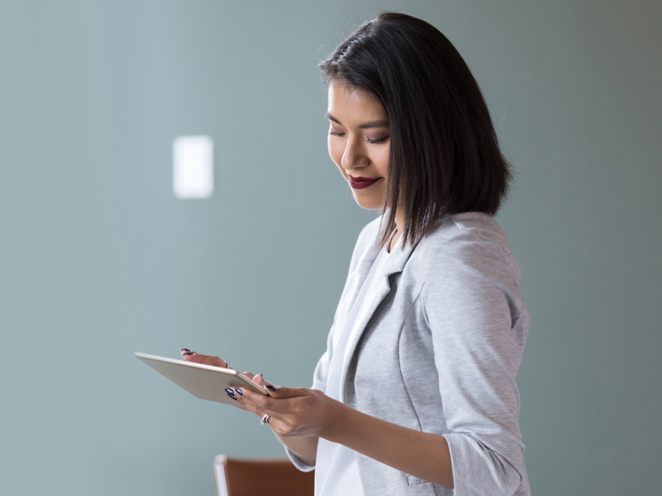 Young Asian woman using tablet computer in office stock photo.