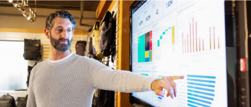 A man pointing at a tv screen in a store.